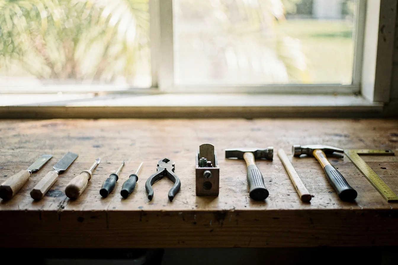 A tidy workbench with hand tools laid out in order in morning light