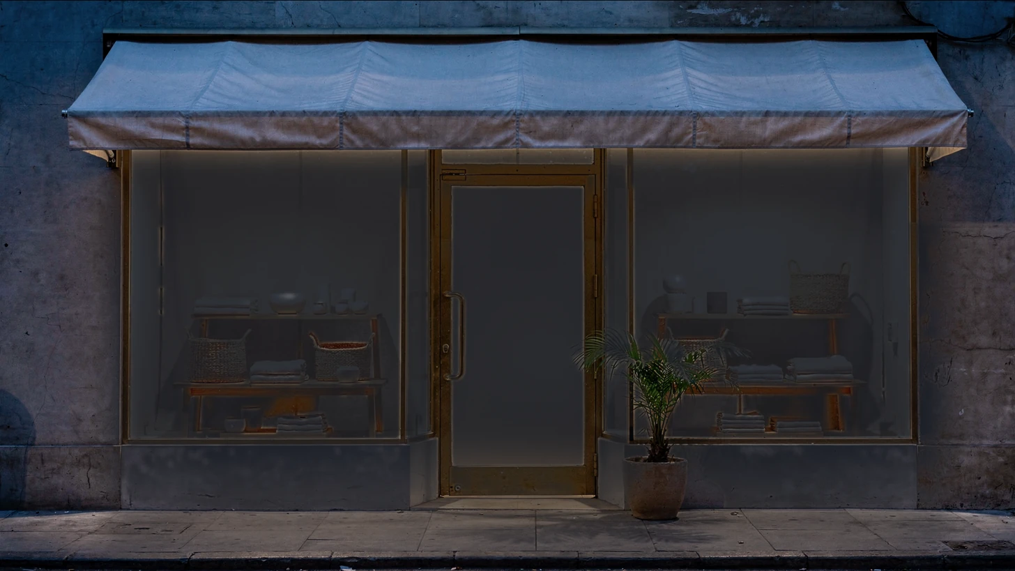 A boutique storefront seen straight-on at dusk, its windows dark and the door shut