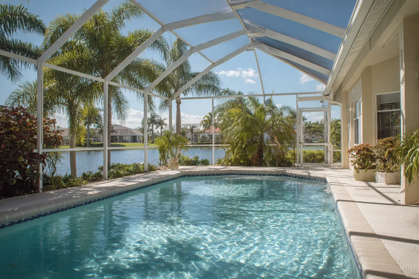 Screened pool enclosure over a pool and lanai behind a Southwest Florida home