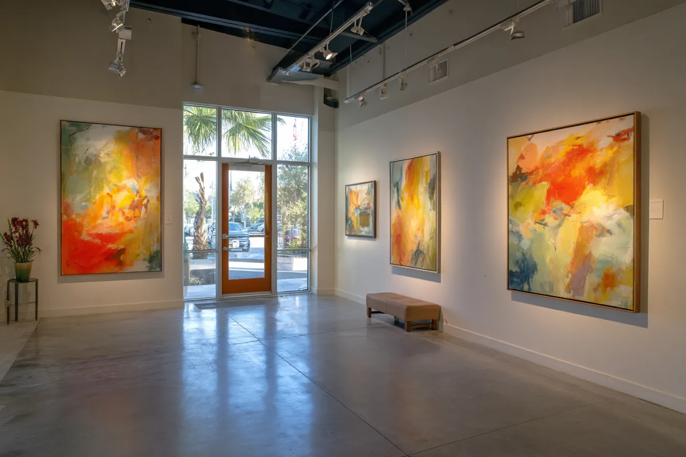 A quiet art gallery interior with blank canvases on white walls and warm afternoon light through tall windows