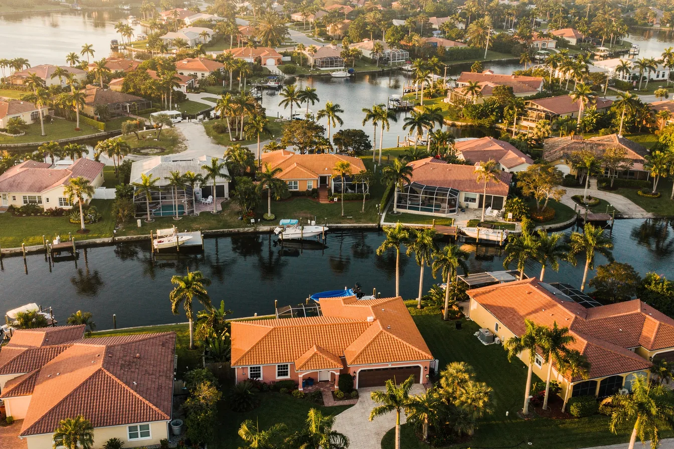 Aerial view of a Southwest Florida coastal neighborhood of canals and tile roofs at golden hour