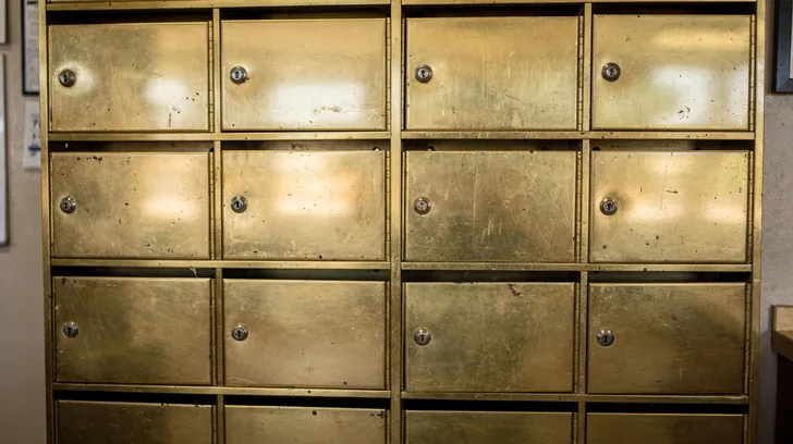 Rows of brass post office boxes in a small post office